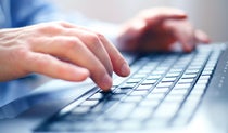 Close up of person typing on a laptop keyboard