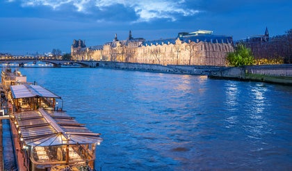 Boats docked along the river Seine at night in Paris
