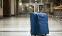 Blue upright standing suitcase at the airport
