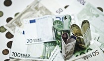 Euro currency notes on a table with three notes upstanding and folded into heart shapes