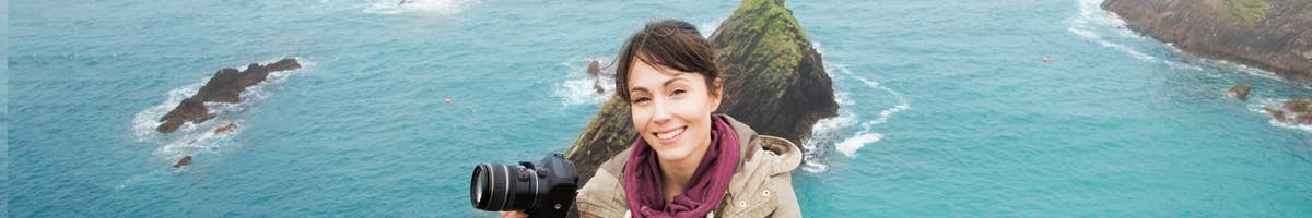 Girl with camera on the Cliffs of Moher