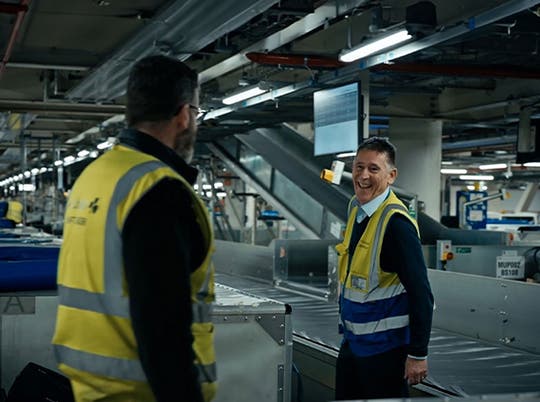 Two male baggage handlers smiling