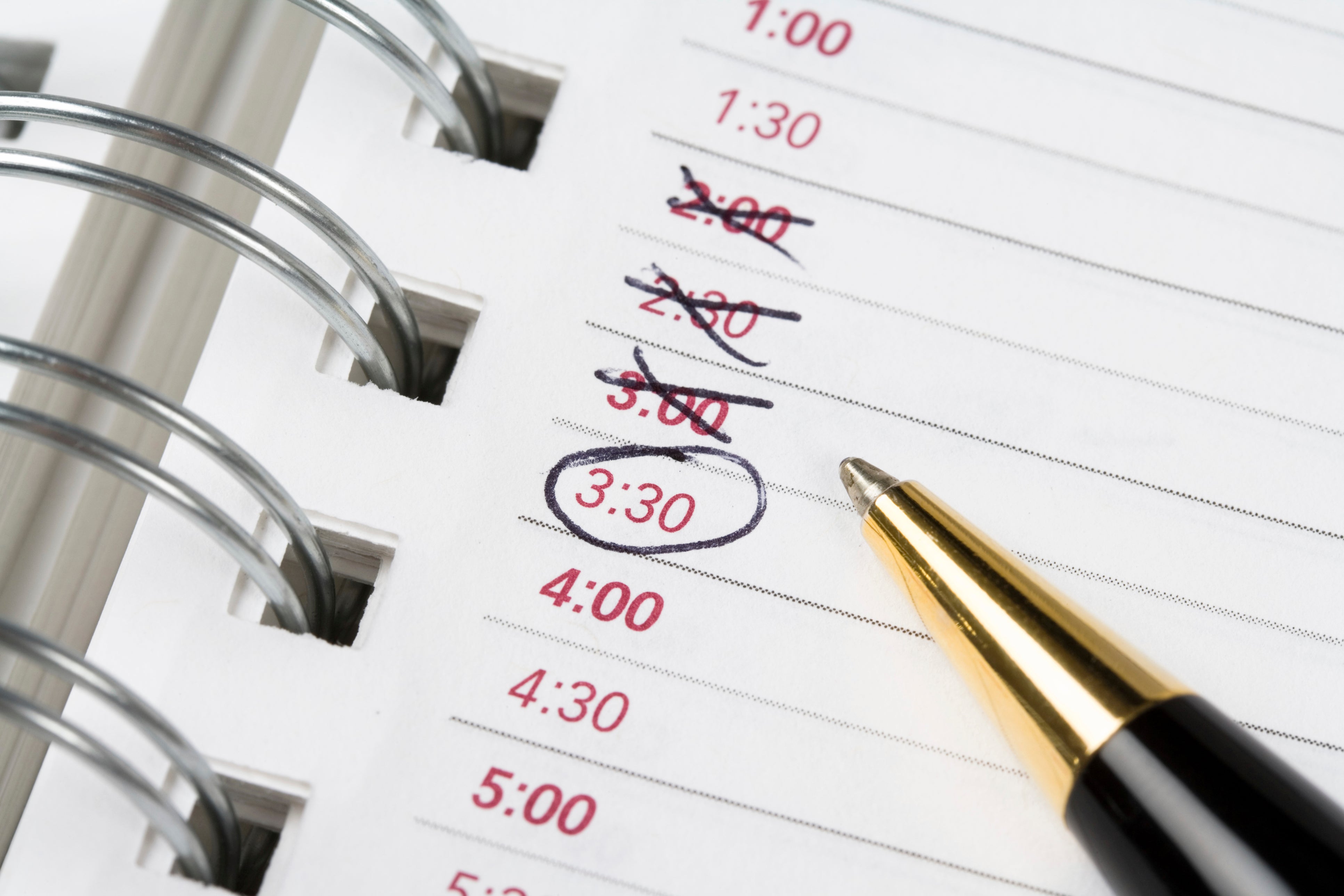 Close up of calendar book with a pen and times circled