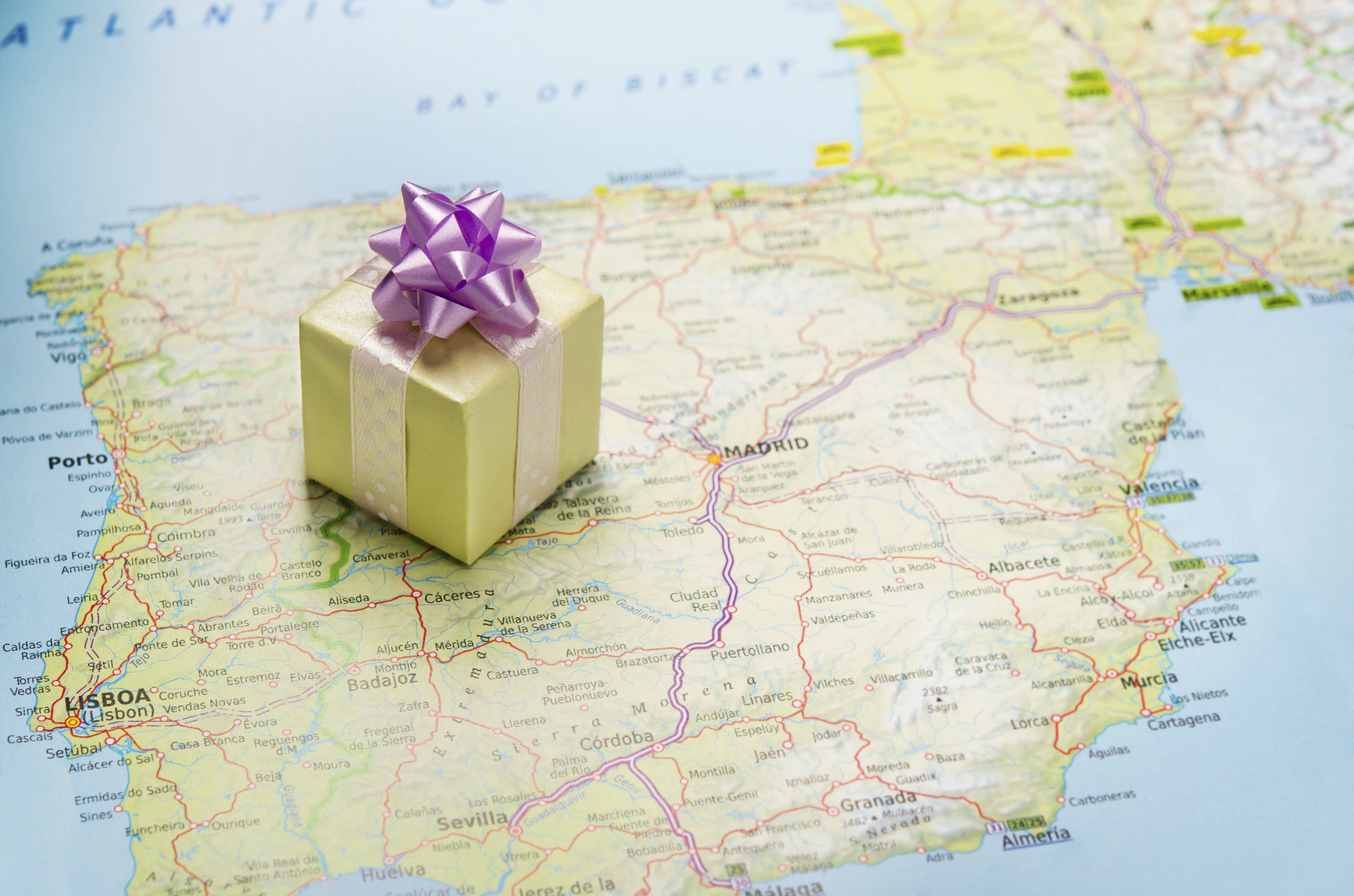 A gift wrapped box sitting on top of a map of Spain
