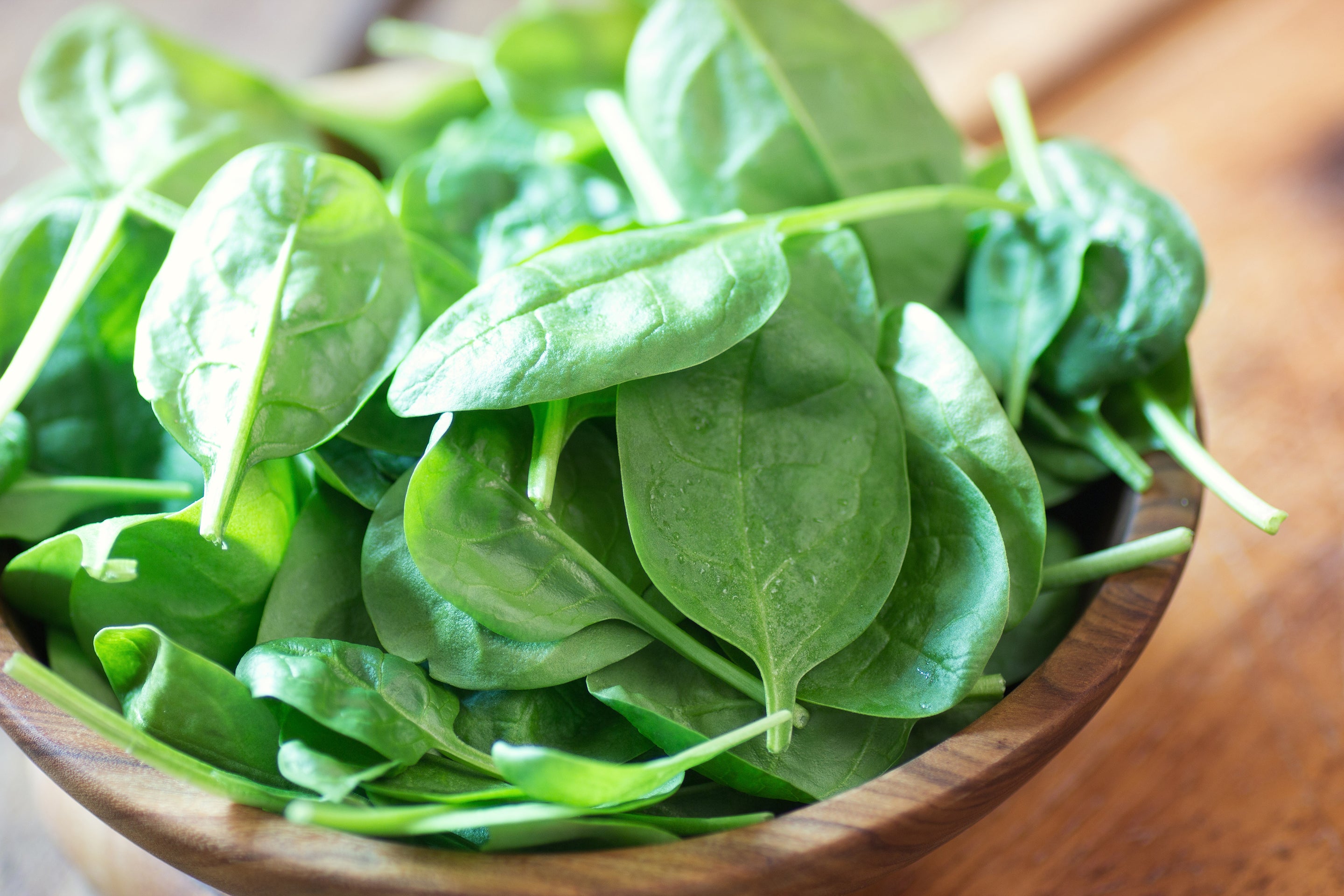 Spinach leaves in a wooden bowl