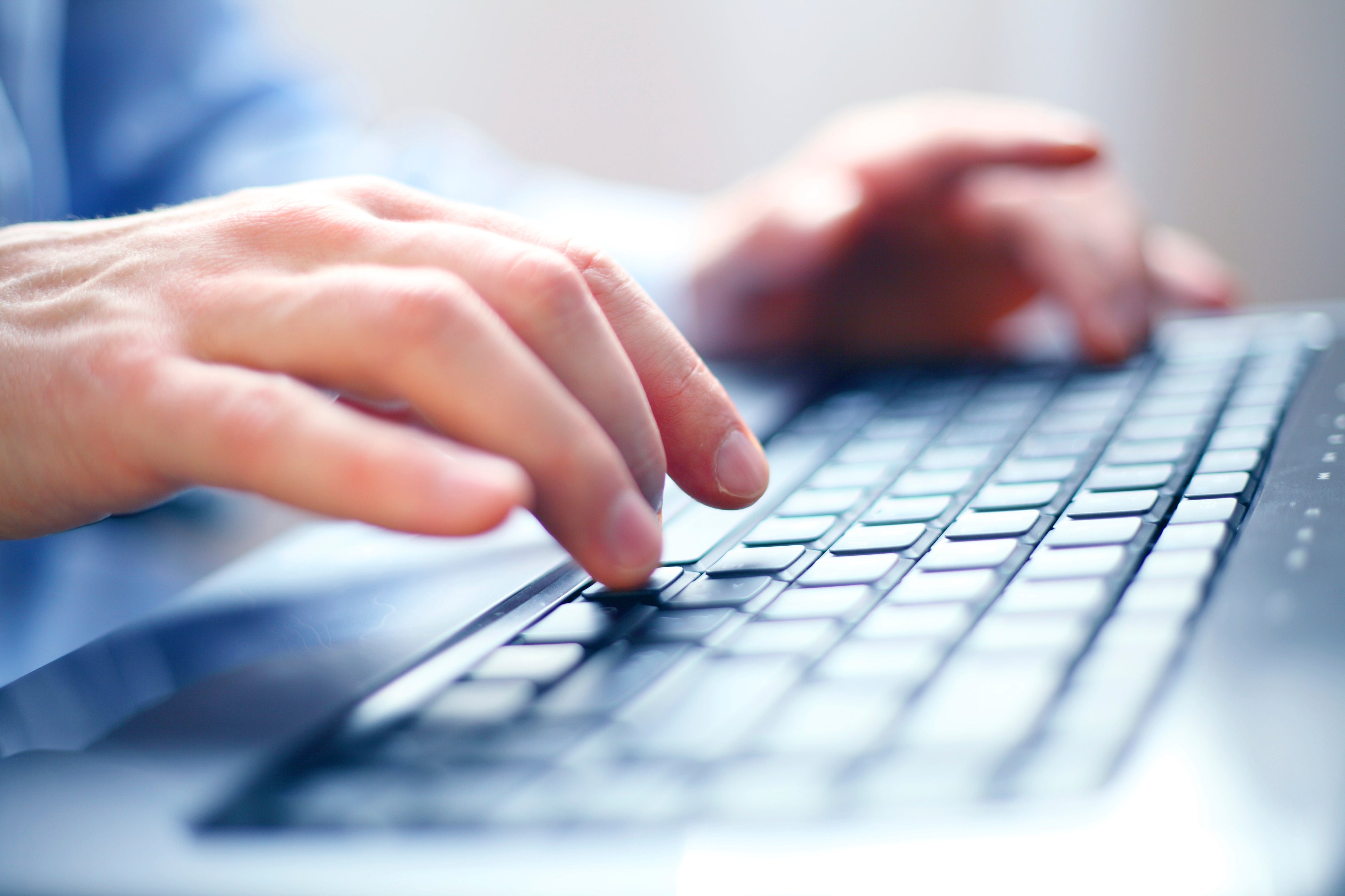 Close up of person typing on a laptop keyboard